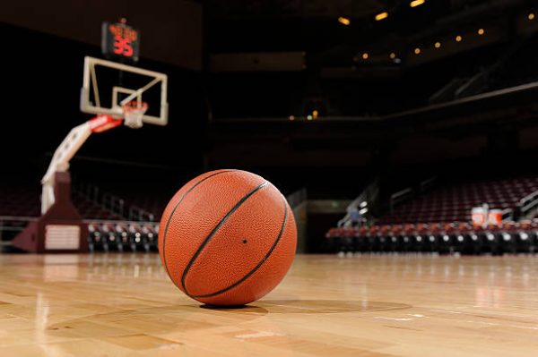 Basketball on the floor of a indoor court.